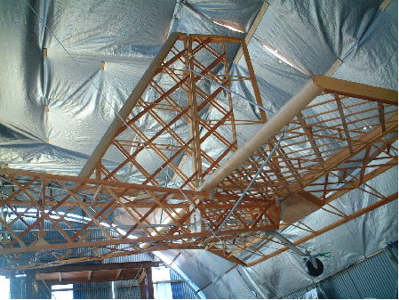 骨組みが完成した尾翼と胴体、格納庫天井に吊って保管　