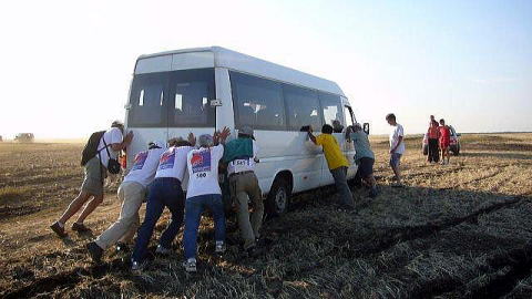 悪路から脱出するため、立ち往生したバスを皆で押す