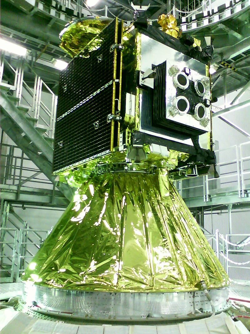図７　打上直前の「はやぶさ２」小惑星探査機（２０１４年１１月、種子島宇宙センターにて）。<br>円錐形のＰＡＦ（Payload Attach Fitting）の上に搭載された探査機。４台のイオンエンジンが見える。